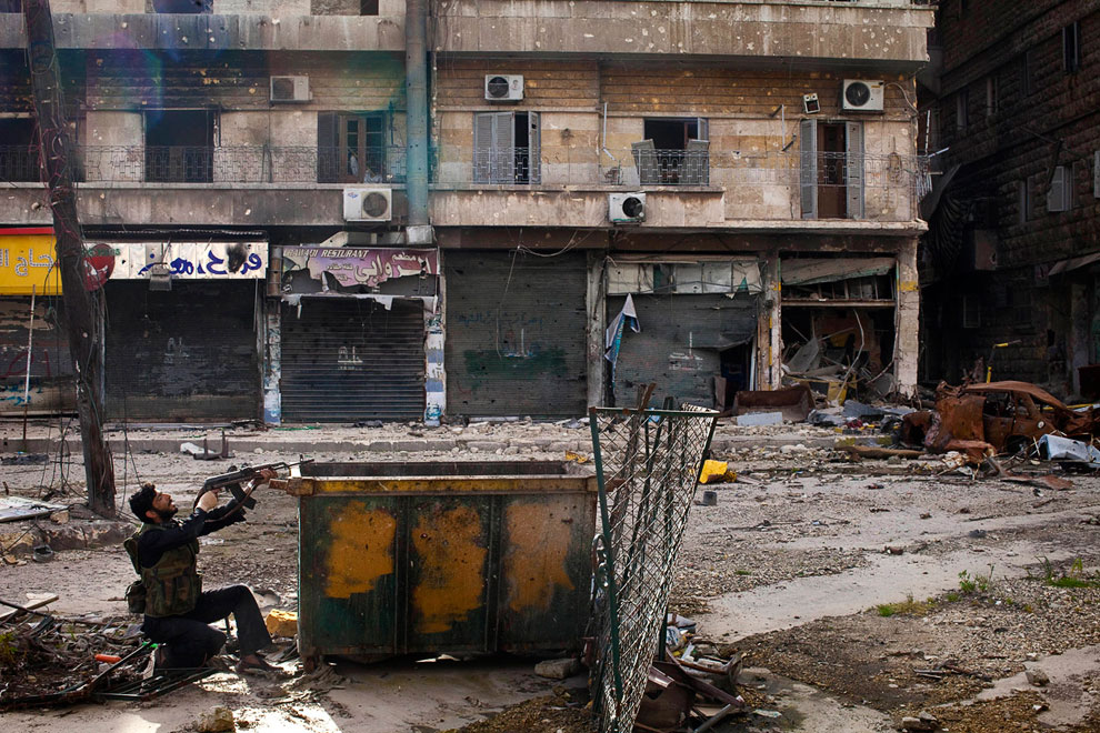 Сирийский мятежник постреливает из-за бака, Алеппо