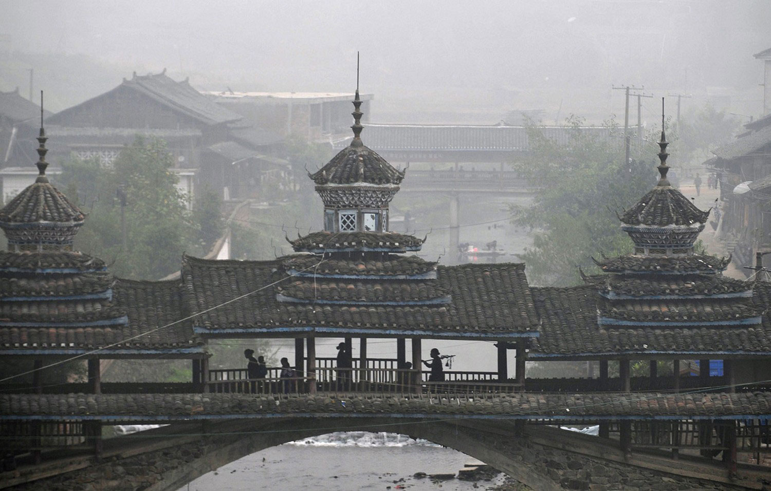китайцы идут по крытому мосту, фото