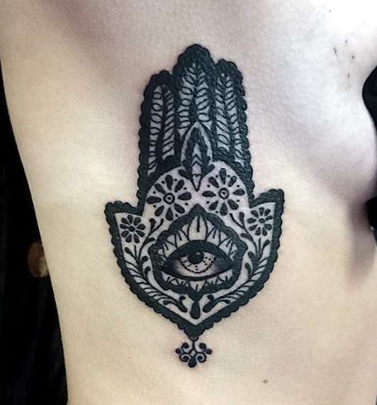 Этническая татуировка на ладони в виде символа ОМ, в котором находится гора глаз