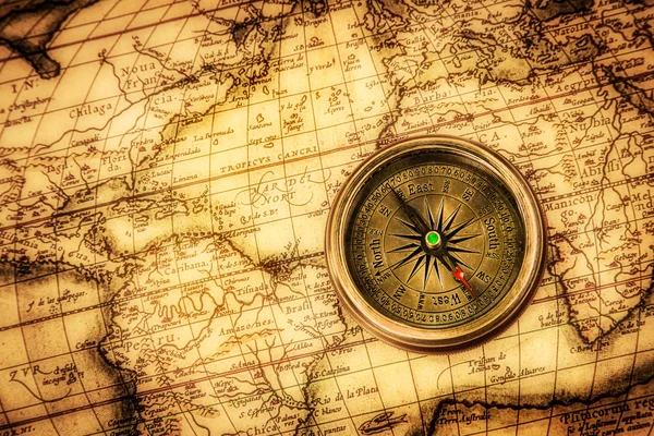 Старинный компас находится на древней мировой карте — стоковое фото