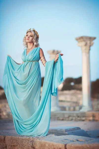 Женщина в греческом стиле на закат возле древних руин — стоковое фото