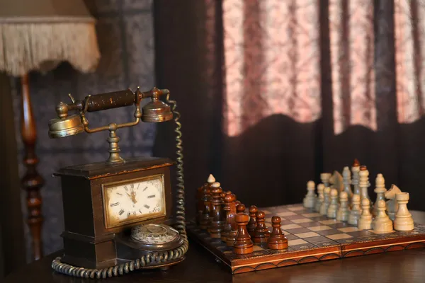 Ретро интерьер комнате деревянные шахматы Маятник настенные часы и телефон — стоковое фото