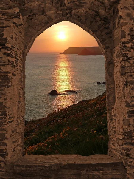 Вид через окно арочной замок закат прибрежный пейзаж, Корнуолл Лицензионные Стоковые Фото