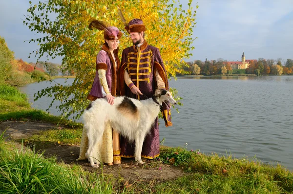 Пара в средневековых костюмах с псовая борзая собака — стоковое фото