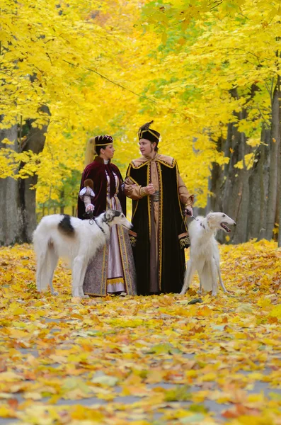 Пара в средневековые костюмы с двумя собаками псовая борзая — стоковое фото