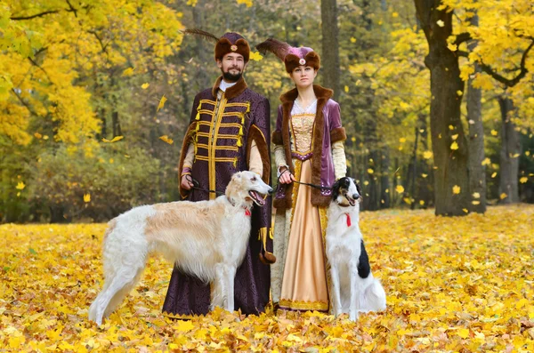 Пара в средневековые костюмы с двумя собаками псовая борзая — стоковое фото