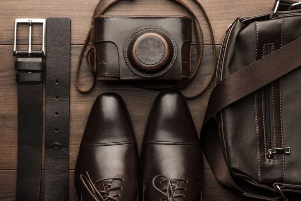 Коричневые ботинки, пояса, сумка и фильм камеры — стоковое фото
