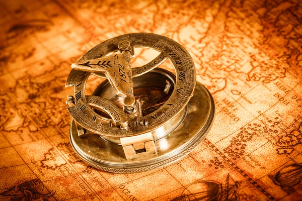 Старинный компас находится на древней мировой карте — стоковое фото