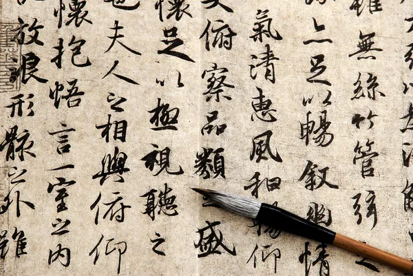 Китайская каллиграфия на бежевой бумаге — стоковое фото