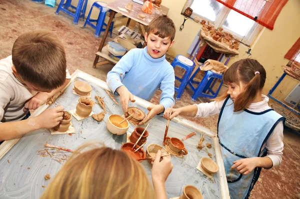 Группа детей, формирование глины в студии керамики — стоковое фото