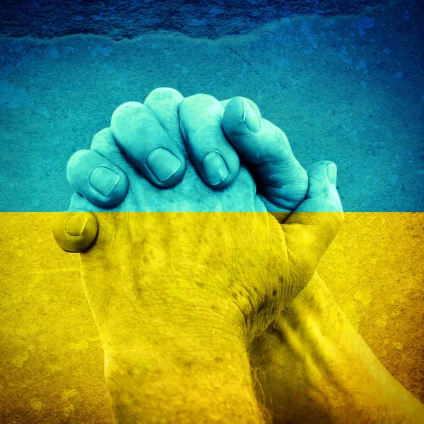 Руки на украинский флаг — стоковое фото