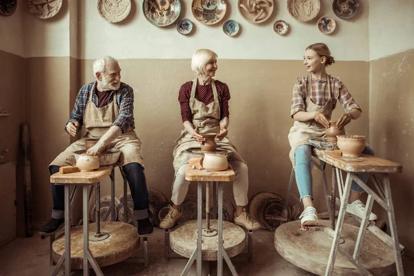 Бабушка и дедушка с внучкой, производящей керамику на мастерской — стоковое фото