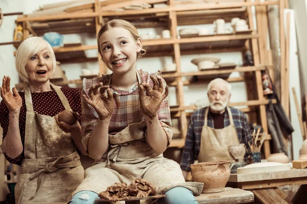Бабушка и дедушка с внучкой, производящей керамику на мастерской — стоковое фото
