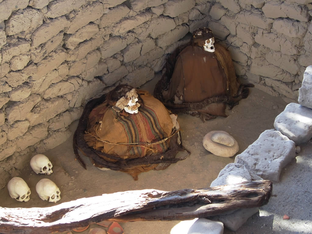 Мумии сидят на корточках в пещере рядом с черепами в Чаучилле, Перу
